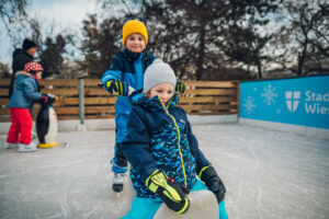 Kinder beim Eislaufen mit Fahrhilfen